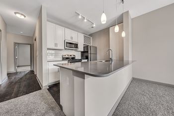 A modern kitchen with a white countertop and cabinets.